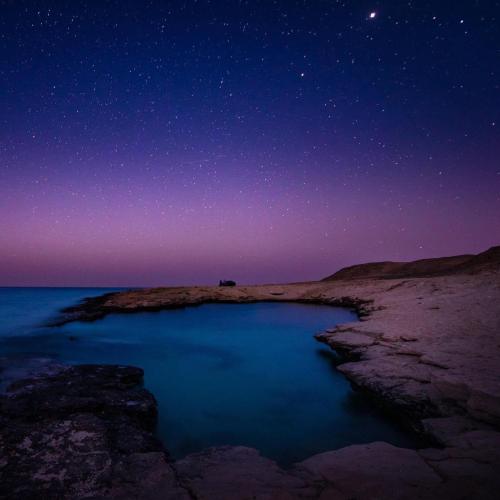 a starry night over a body of water at Alam B&B in Marsa Alam City