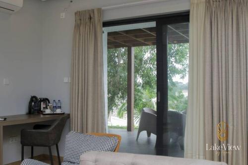 een woonkamer met een bureau en een raam bij Executive Suite Apartment in Cape Coast - Lakeview by Agnes in Cape Coast