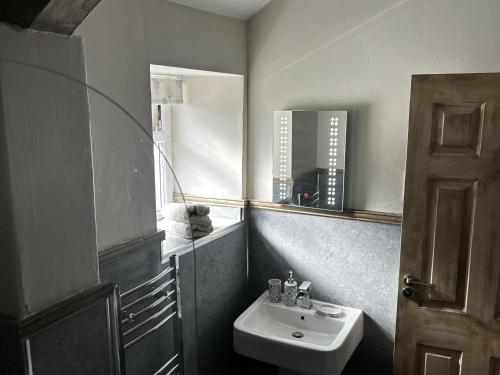 y baño con lavabo blanco y espejo. en Cosy 2-Bed Cottage in Heysham Village Morecambe, en Morecambe