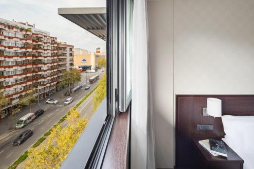 a room with a window with a view of a city at Hotel Lugano Barcelona in Barcelona