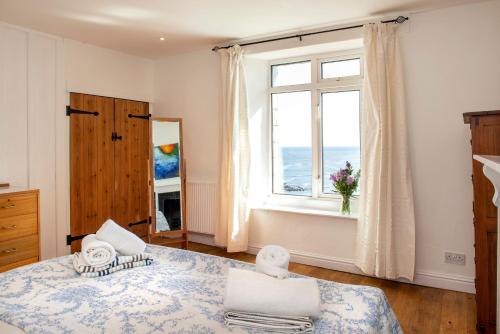 a bedroom with a bed and a large window at Hawkins Cottage with Hot Tub in Torpoint