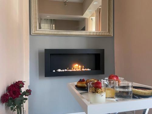 a fireplace in a living room with a table with food at Casa Rosmini rooms, Dolomia best home in Trento
