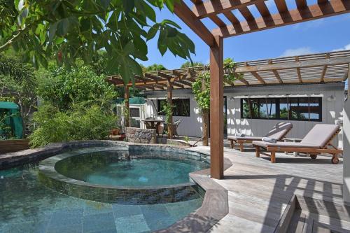 a swimming pool in a backyard with a pergola at Case Canne a sucre in Saint Barthelemy