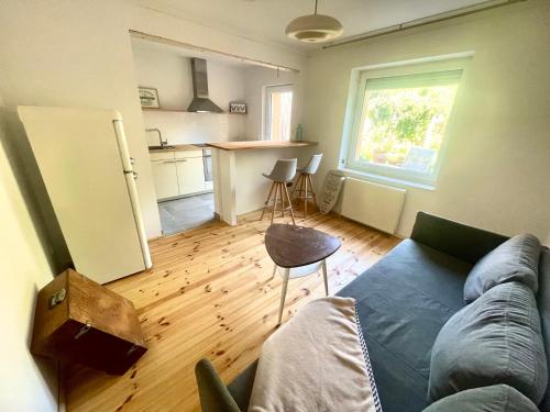 uma sala de estar com um sofá e uma cozinha em Weener - City Apartment mit Garten em Weener