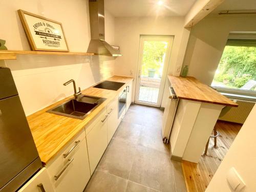 uma cozinha com um lavatório e uma bancada em Weener - City Apartment mit Garten em Weener