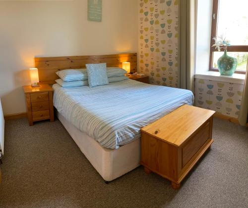 a bedroom with a bed and a table and a window at Thurso Bay Holidays in Thurso