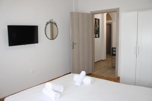 een slaapkamer met een bed met witte lakens en een spiegel bij Athens City Themis 16 in Athene