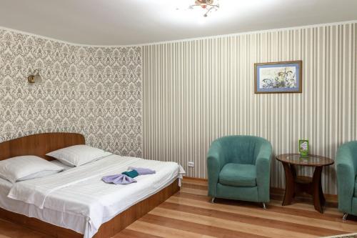1 dormitorio con 1 cama, 2 sillas y mesa en Кейптаун, en Petropavlovsk