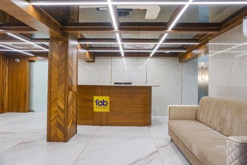 a lobby with a couch and a yellow sign on the ceiling at FabHotel Prime Shourya Residency in Pune