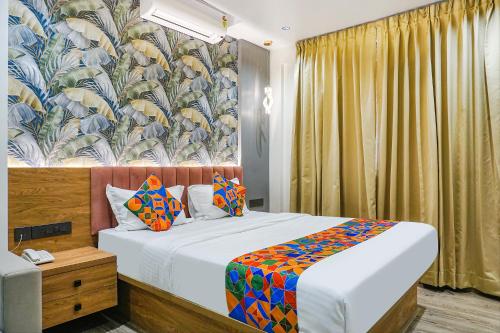 1 dormitorio con 1 cama y papel pintado con motivos florales en FabHotel Prime Shourya Residency, en Pune