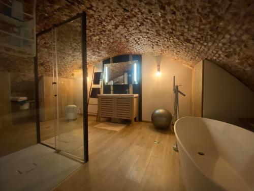 uma casa de banho com uma cabina de duche em vidro e uma banheira em Au Beau Lieu de Metz em Lille
