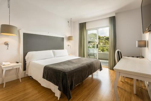 a hotel room with a large bed and a window at ARTIEM Audax - Adults Only in Cala Galdana