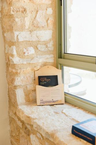a box sitting on a window sill next to a brick wall at אבן על הנחל in Merhav Am