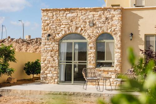 a patio with chairs and a table in front of a building at אבן על הנחל in Merhav Am