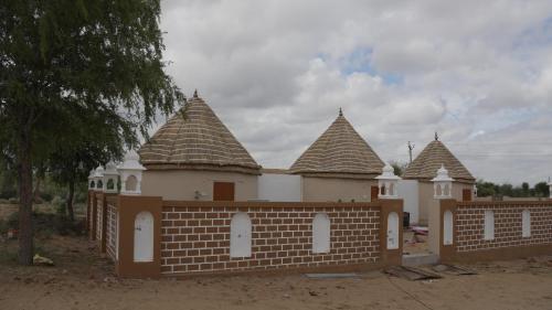 a building with turrets and a brick fence at Bikaner Desert Camp and Resort in Bikaner