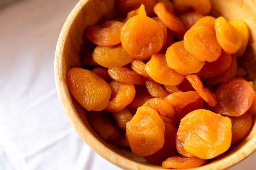 a wooden bowl filled with peeled orange fruit at Dunas Luxury Beach Resort Tarifa in Tarifa