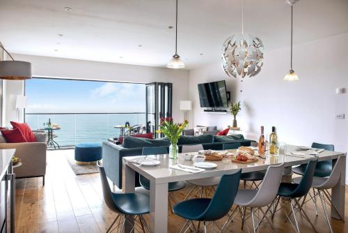 a dining room and living room with a table and chairs at Sandpiper in Torpoint
