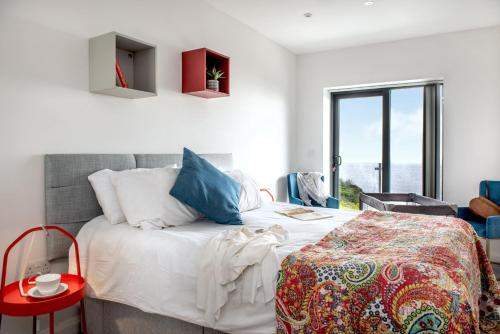 a bedroom with a large bed and a red table at Sandpiper in Torpoint