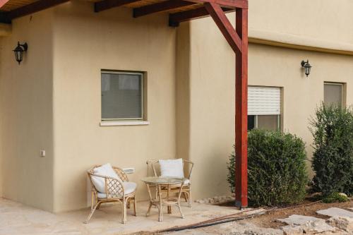 a patio with chairs and a table in front of a house at אבן על הנחל in Merhav Am