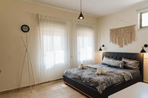 a bedroom with a bed and a clock on the wall at אבן על הנחל in Merhav Am