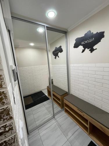 uma sauna com dois bancos e uma placa na parede em FAMILY apartment em Vinnytsya