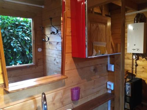 a wooden cabin with a sink and a window at petite location insolite d un chalet in Saran