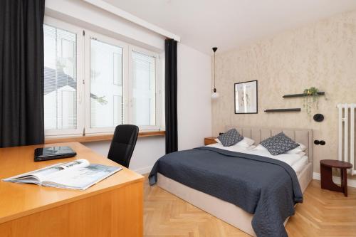 a bedroom with a bed and a desk and window at Apartment with Balcony Gdynia Downtown by Renters in Gdynia