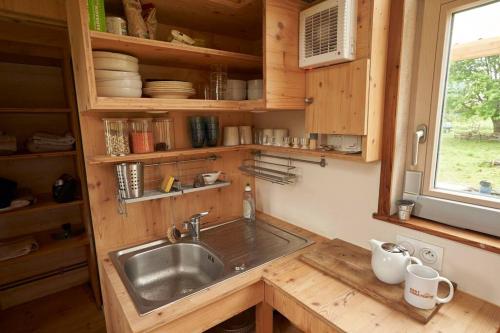 una cucina con lavandino in una casetta minuscola di Tiny house near the Mont-Saint-Michel a Ducey