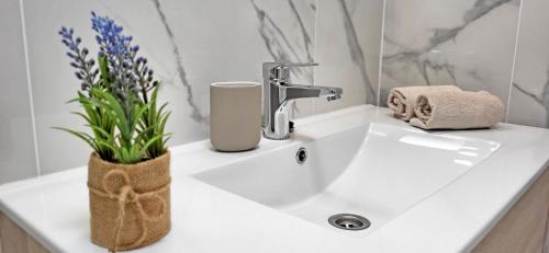 a bathroom sink with a faucet and flowers on it at Ferienwohnung OCEAN SOUNDS 2 in Gran Tarajal