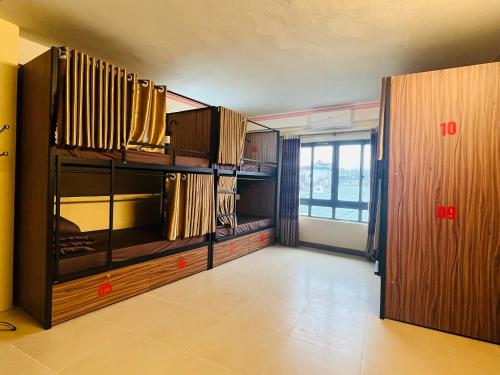 Happy Family Hotel في سابا: غرفة فارغة بها دواليب خشبية ونافذة كبيرة