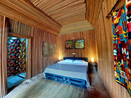 a bedroom with a bed in a wooden room at Bel Ami in Ouidah