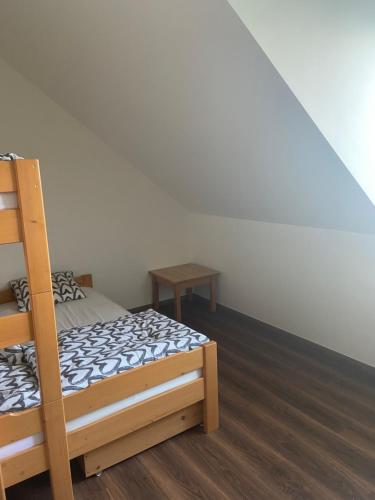 een slaapkamer met een stapelbed en een houten vloer bij Horský apartmán pod Ještědem in Liberec