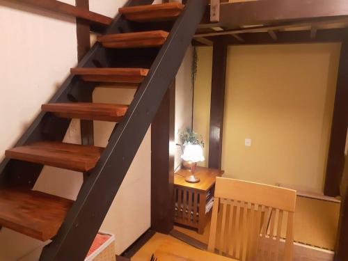 a staircase in a room with a table and a lamp at HAKUBA IKEDA LIFE KAN APARTMENTS in Hakuba