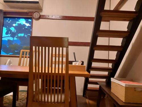a dining room with a wooden table and a staircase at HAKUBA IKEDA LIFE KAN APARTMENTS in Hakuba