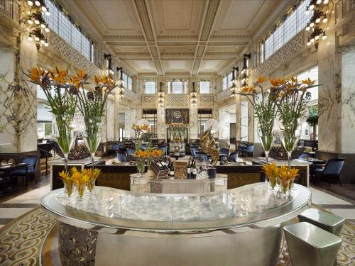 a lobby with a large room with tables and chairs at Park Hyatt Vienna in Vienna