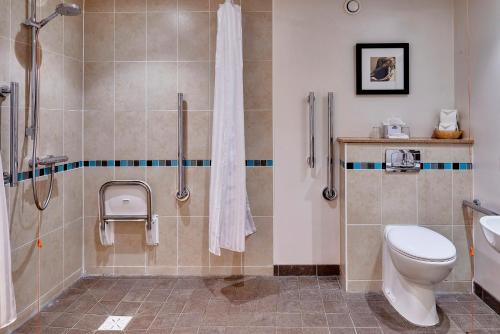 a bathroom with a shower and a toilet and a sink at Staybridge Suites Liverpool by IHG in Liverpool
