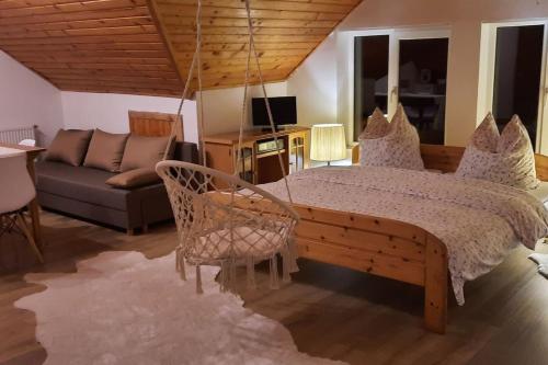 um quarto com uma cama e um sofá em Casa din Poiana Garâna em Garana