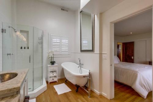 a bathroom with a tub and a sink and a bed at Cozy Craftsman Bungalow, Hillcrest/Mission Hills in San Diego