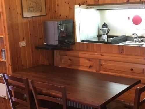 cocina con mesa, microondas y fregadero en Zeta House en Rivisondoli