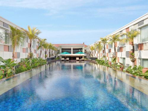 a swimming pool in the middle of a building at Novotel Bali Ngurah Rai Airport in Kuta