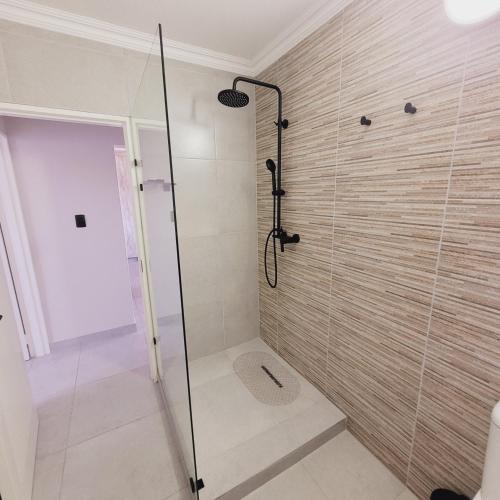 a shower with a glass door in a bathroom at Blaasoppie 202 in Mossel Bay