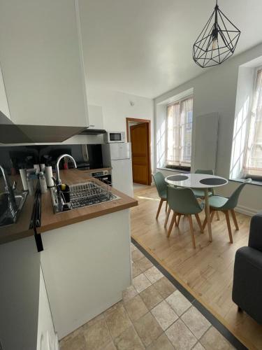 une cuisine et un salon avec une table et des chaises dans l'établissement Appartement Le Petit Charcot, à Charleville-Mézières