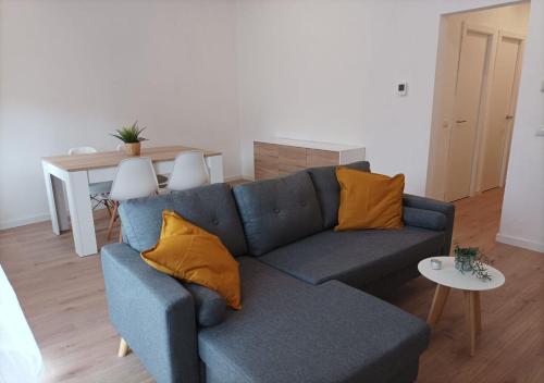 un divano blu con cuscini gialli in soggiorno di NUEVO Apartamento Centro Lleida a Lleida