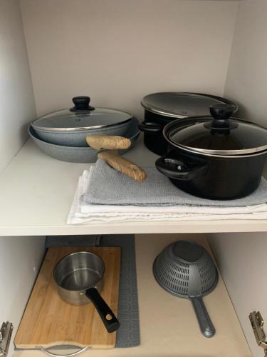 a shelf with two pots and pans and a whisk at Victoriei Boulevard Private Apartment in Braşov