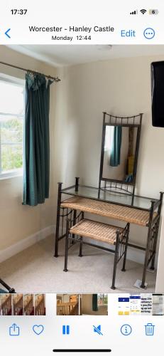 a room with a table and a mirror and a bench at Gilberts End Farm in Great Malvern