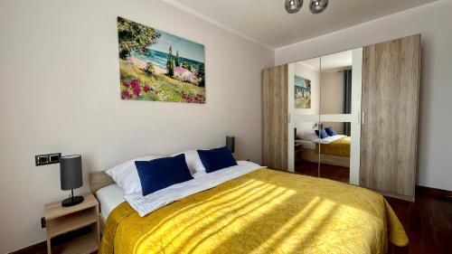 1 dormitorio con 1 cama con colcha amarilla en Mala Italia Apartments, en Wroclaw