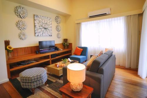 a living room with a couch and a tv at Sutera Sanctuary Lodges At Manukan Island in Kota Kinabalu