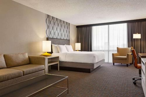 a hotel room with a bed and a couch at Wyndham Fort Smith City Center in Fort Smith