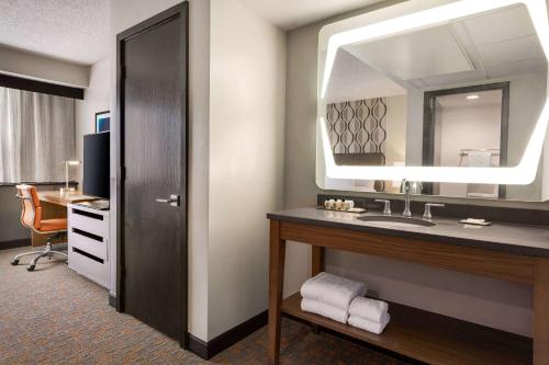 a hotel room with a sink and a mirror at Wyndham Fort Smith City Center in Fort Smith