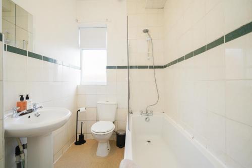 a bathroom with a sink and a toilet and a bath tub at Stadium View, entire private house, close to city centre, free WiFi in Sheffield